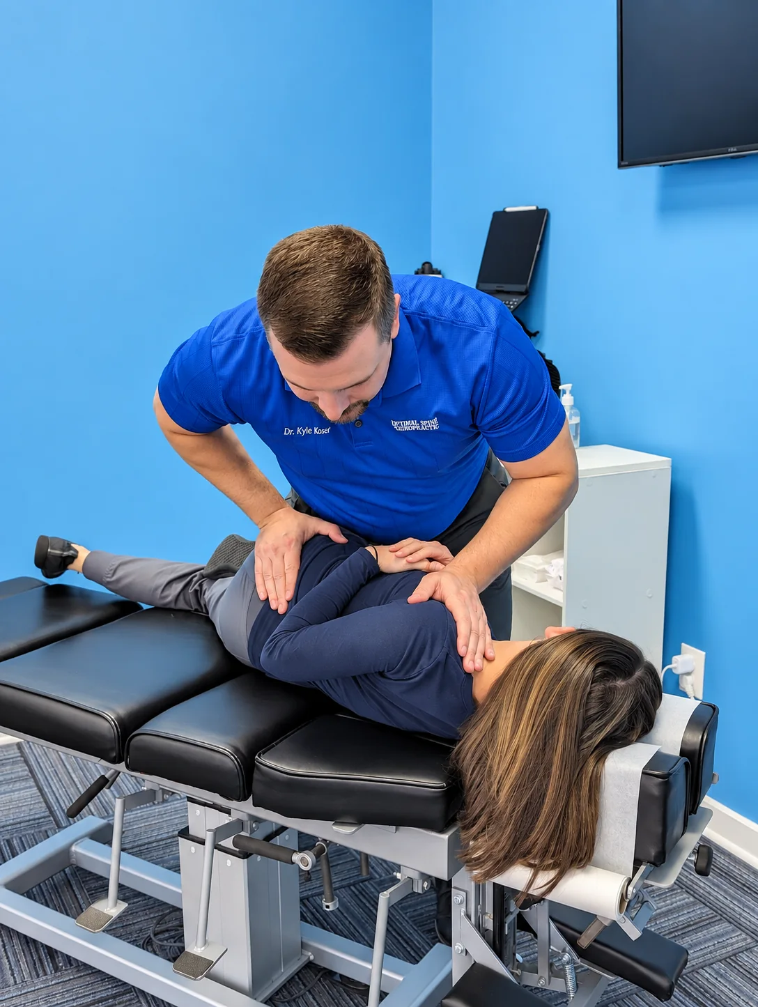 Dr. Koser demonstrating a side-posture adjustment in the clinic