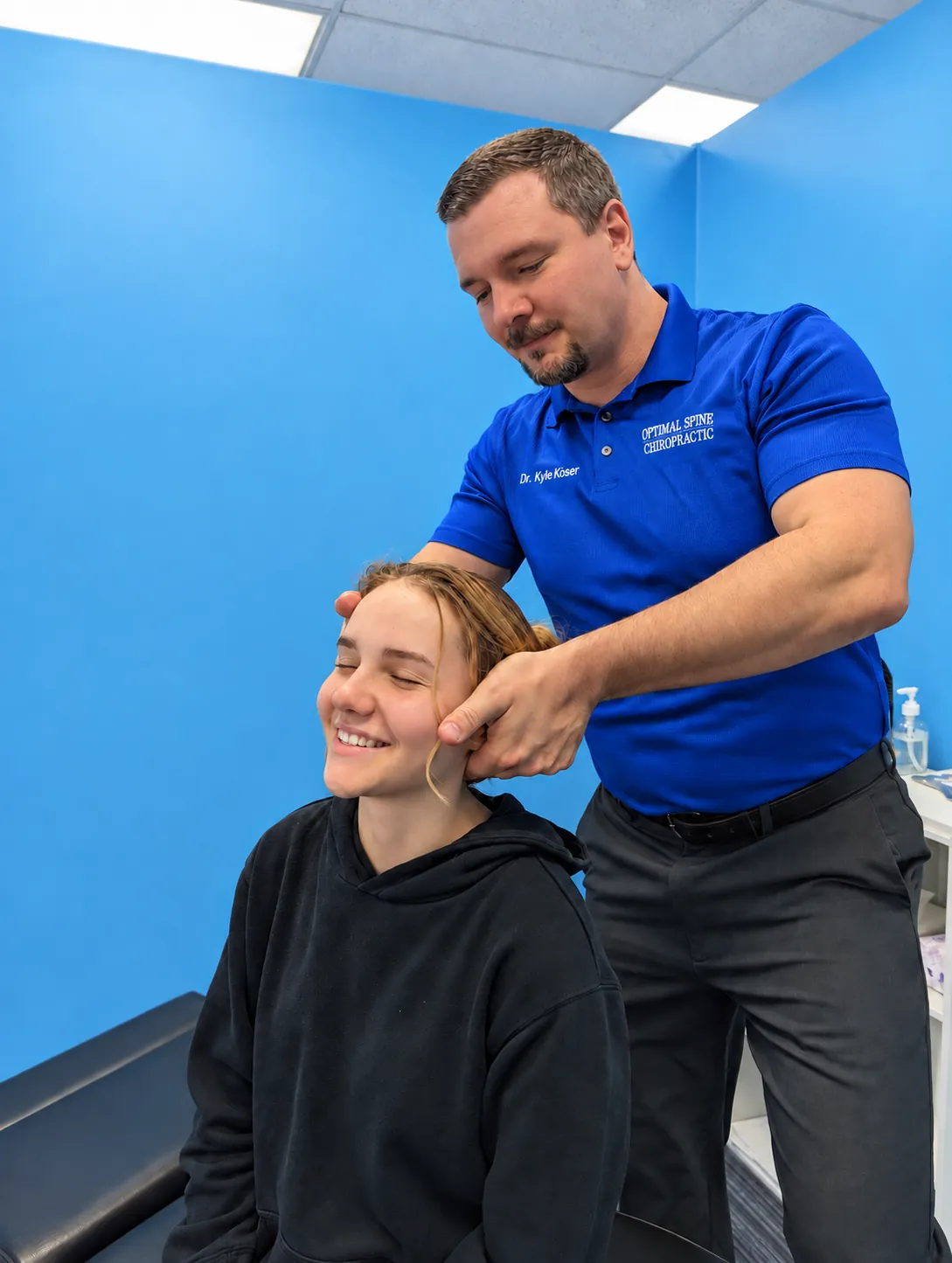 Dr. Koser demonstrating a seated chiropractic adjustment