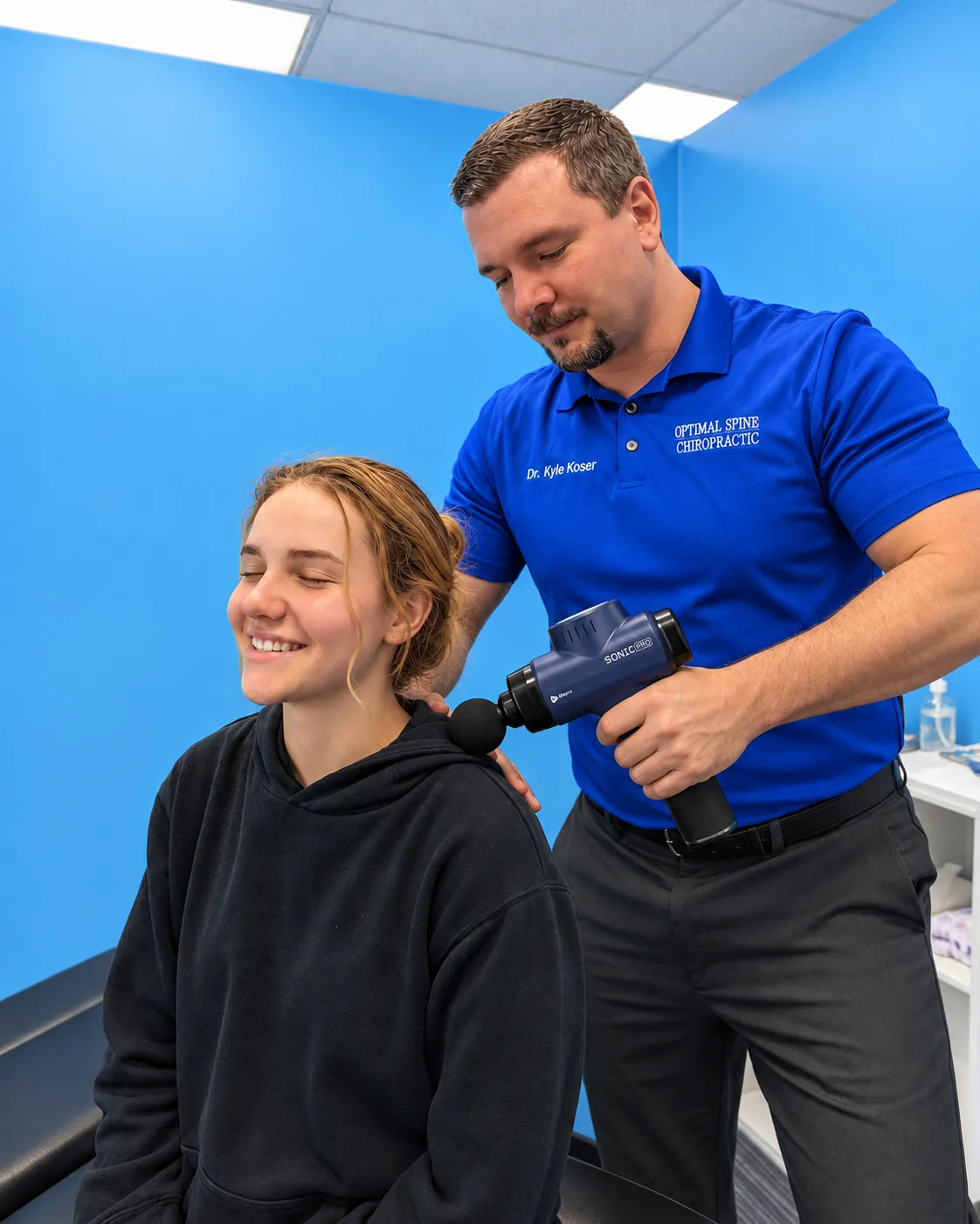 AI mockup of Dr. Koser demonstrating shoulder percussion with a blue LifePro Sonic Pro massage gun